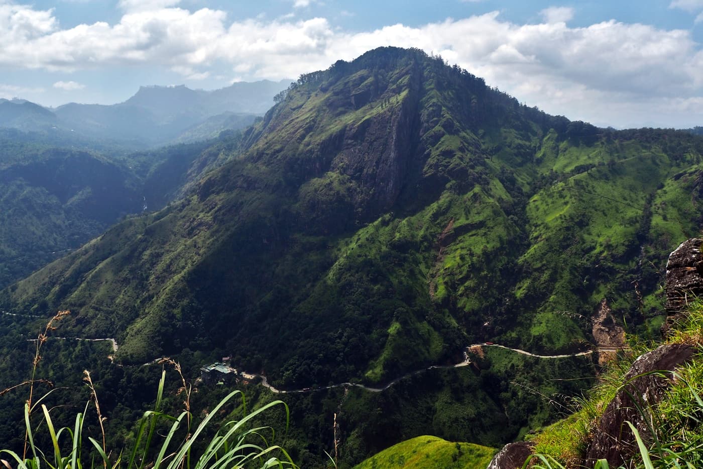 Panoramic view of Ella village nestled in Sri Lanka's Hill Country, surrounded by misty mountains and rolling tea plantation hills