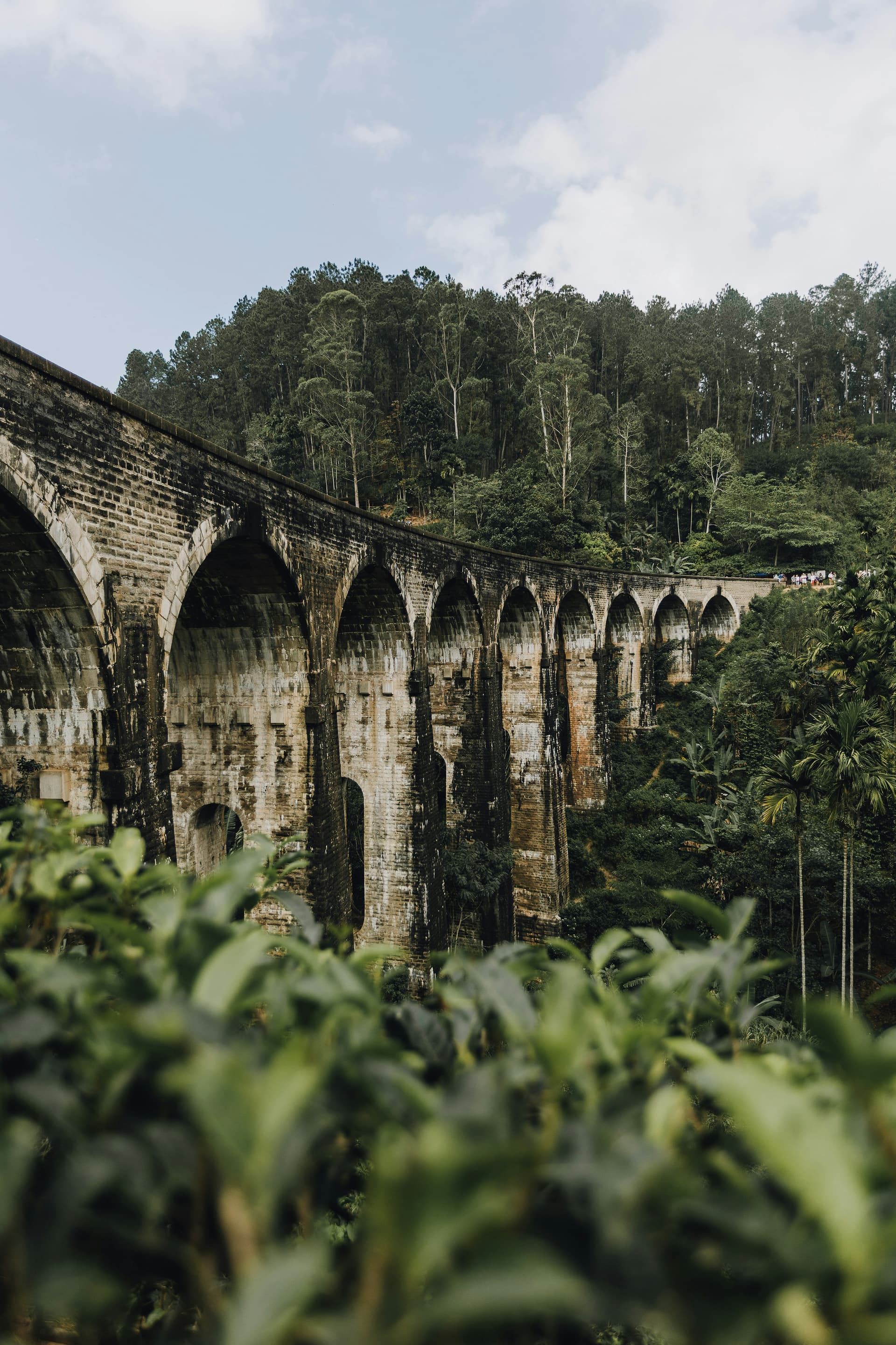Sri Lanka's iconic Nine Arch Bridge in Ella surrounded by lush green tea estates - a highlight of the classic two-week Sri Lanka itinerary