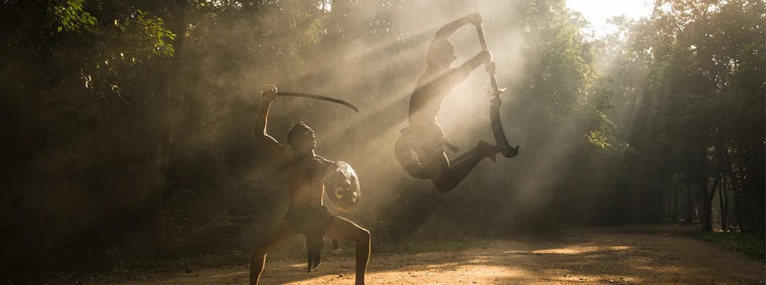 Angampora practitioner training with traditional weapons in misty outdoor setting, Sri Lanka