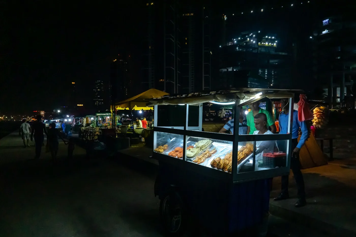 Illuminated street food carts along Galle Face Green in Colombo at night - Sri Lanka's most iconic cheap eat spot