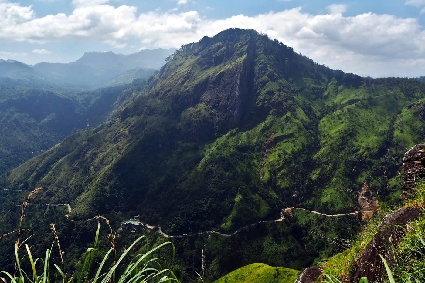 Panoramic view of Ella village nestled in Sri Lanka's Hill Country, surrounded by misty mountains and rolling tea plantation hills