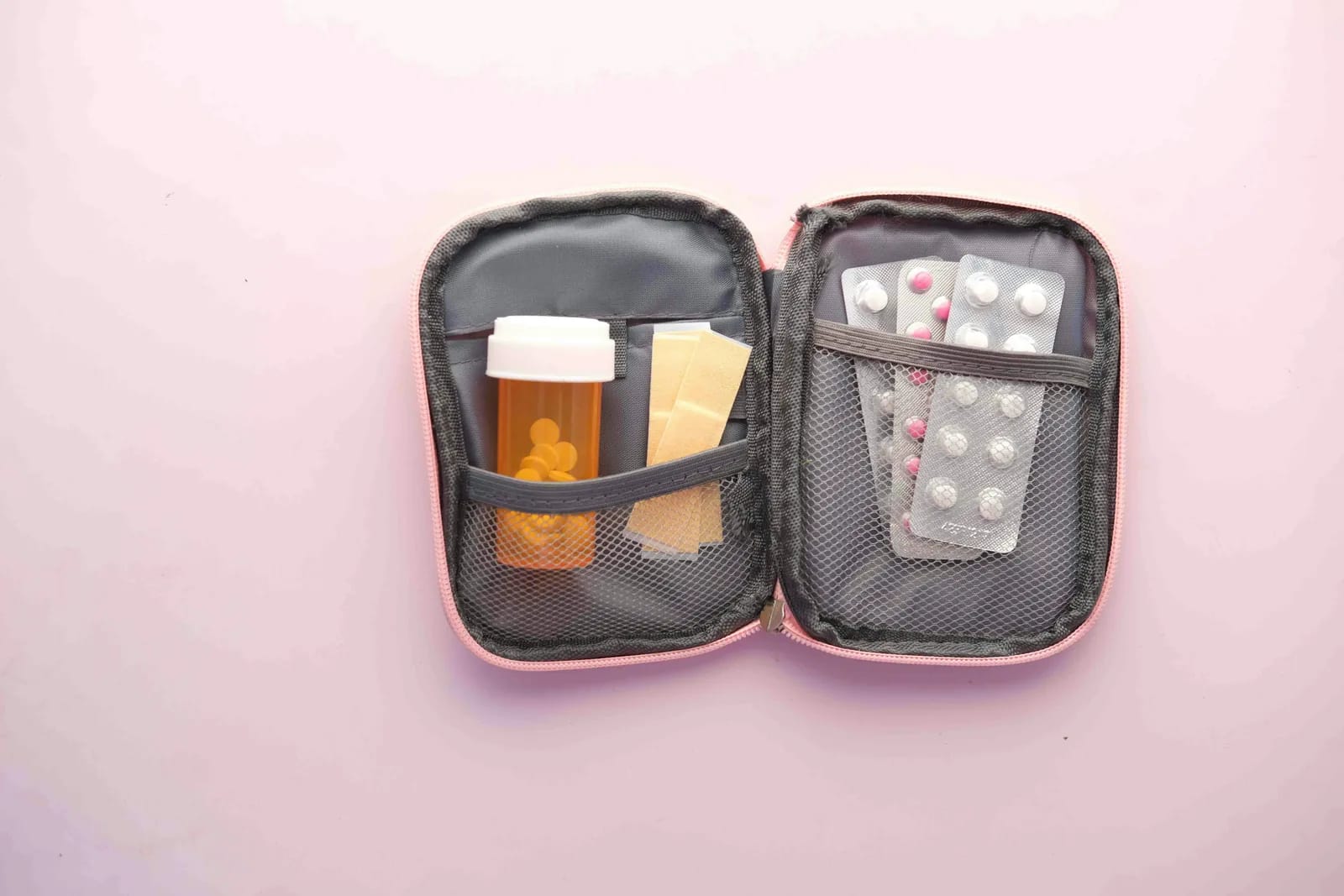 Open travel medicine kit with pill bottles, blister packs of tablets and band-aids - essential health supplies for a Sri Lanka trip