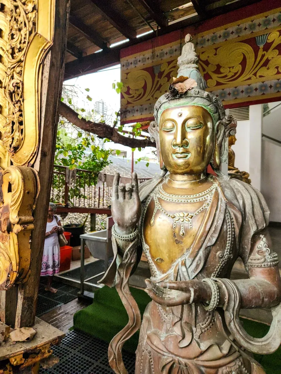 The elaborate interior of Gangaramaya Buddhist Temple in Colombo, Sri Lanka, with golden Buddha statues and ornate decoration