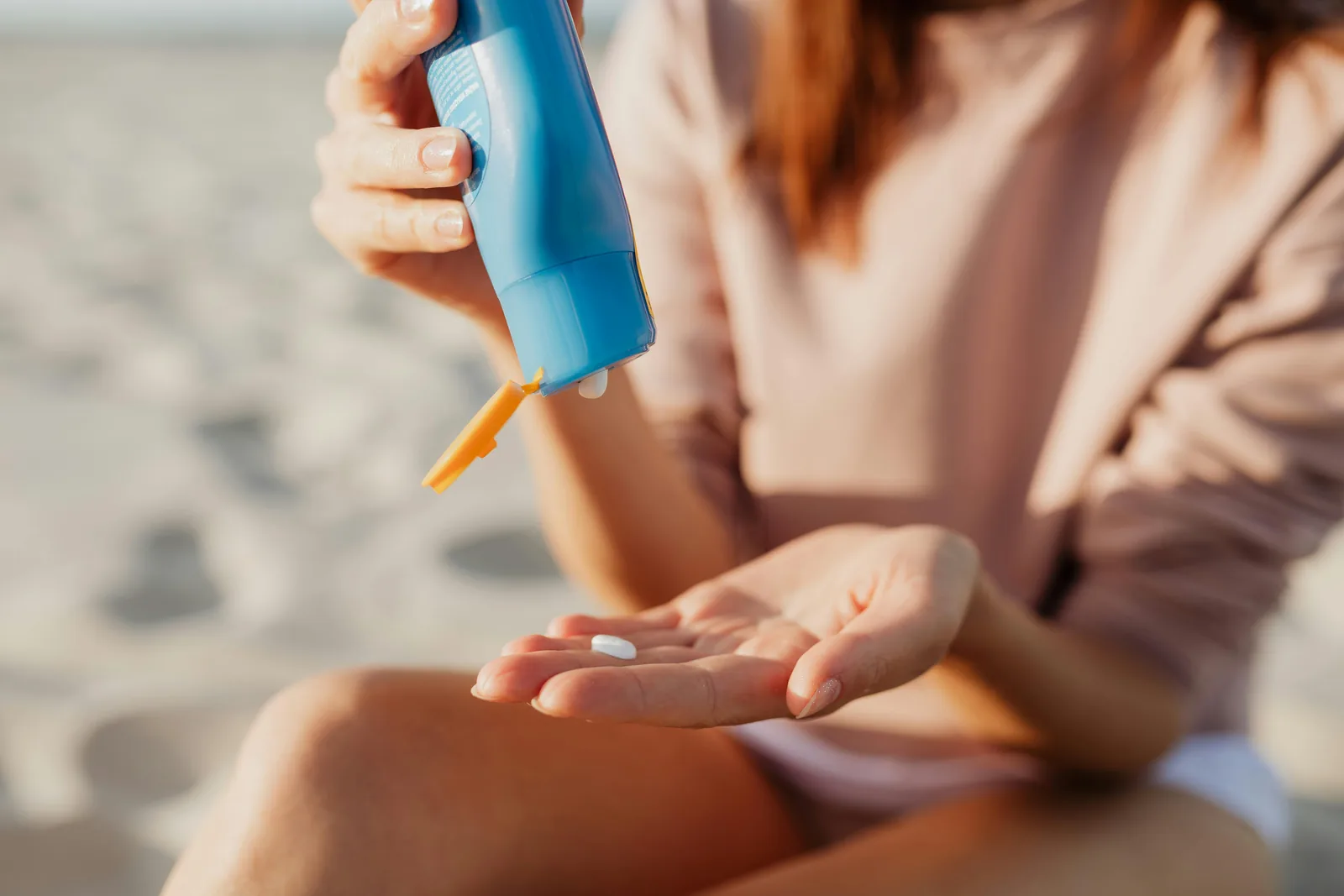Traveller applying sunscreen lotion at the beach in tropical sunshine - sun and insect protection are essential in Sri Lanka
