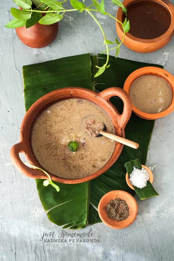 A bowl of freshly made Kola Kanda Sri Lankan herbal porridge with a deep green colour from fresh herb extract, served in a traditional clay bowl