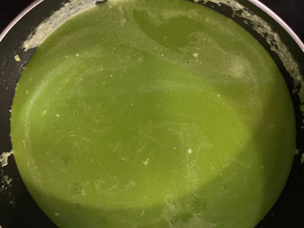 Kola Kanda herbal porridge served warm in a bowl with a small piece of jaggery on the side
