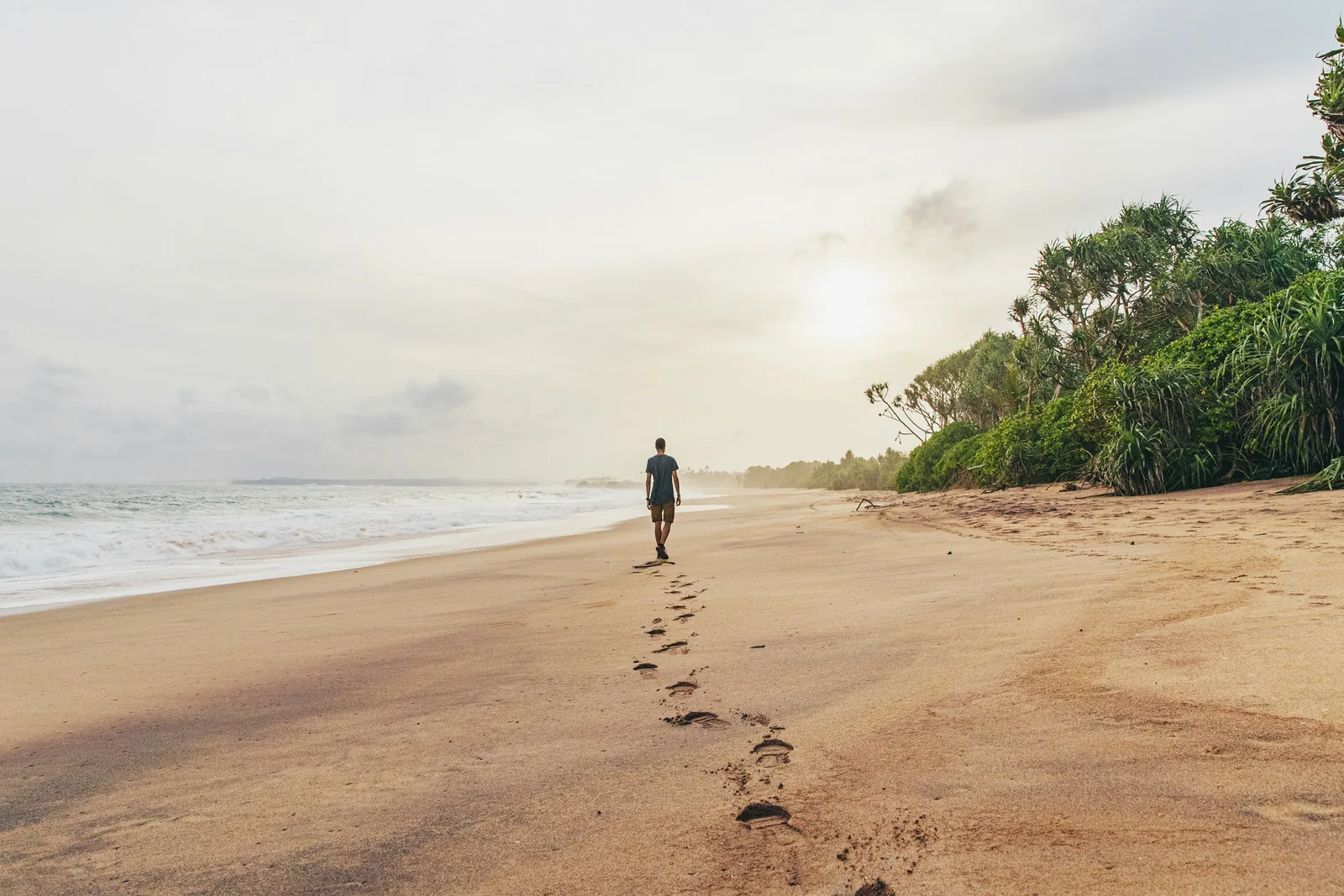 A wide empty sandy beach at Tangalle on Sri Lanka's south coast with dramatic sky and gentle waves, virtually deserted in late afternoon