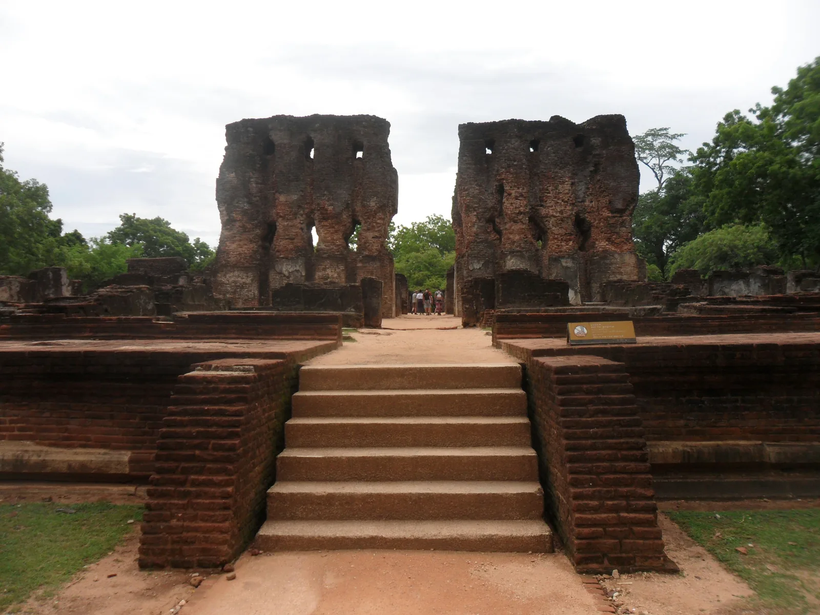 Wide stone steps leading up to the crumbling brick arches of the Royal Palace of Parakramabahu in Polonnaruwa, Sri Lanka