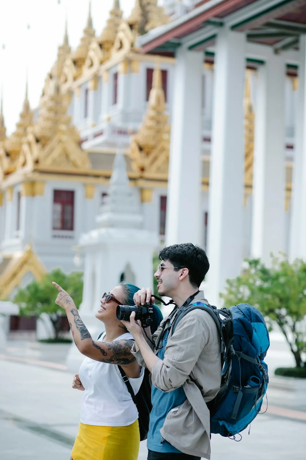 Tourists visiting a Buddhist temple in Sri Lanka, photographing the ornate architecture