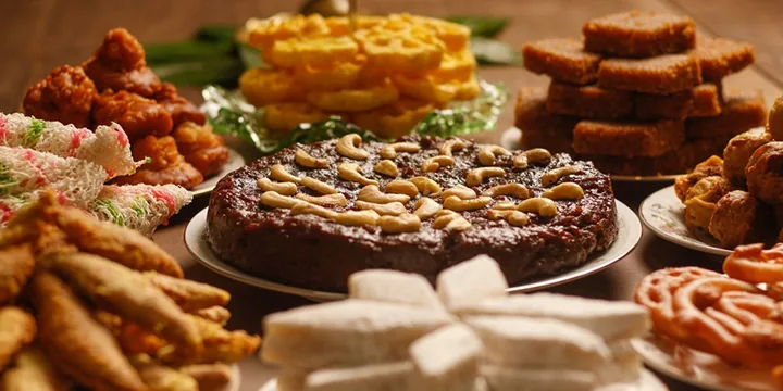 Traditional Sri Lankan Avurudu food spread including kiribath milk rice, kavum oil cakes, kokis, and sweet confections arranged on a table