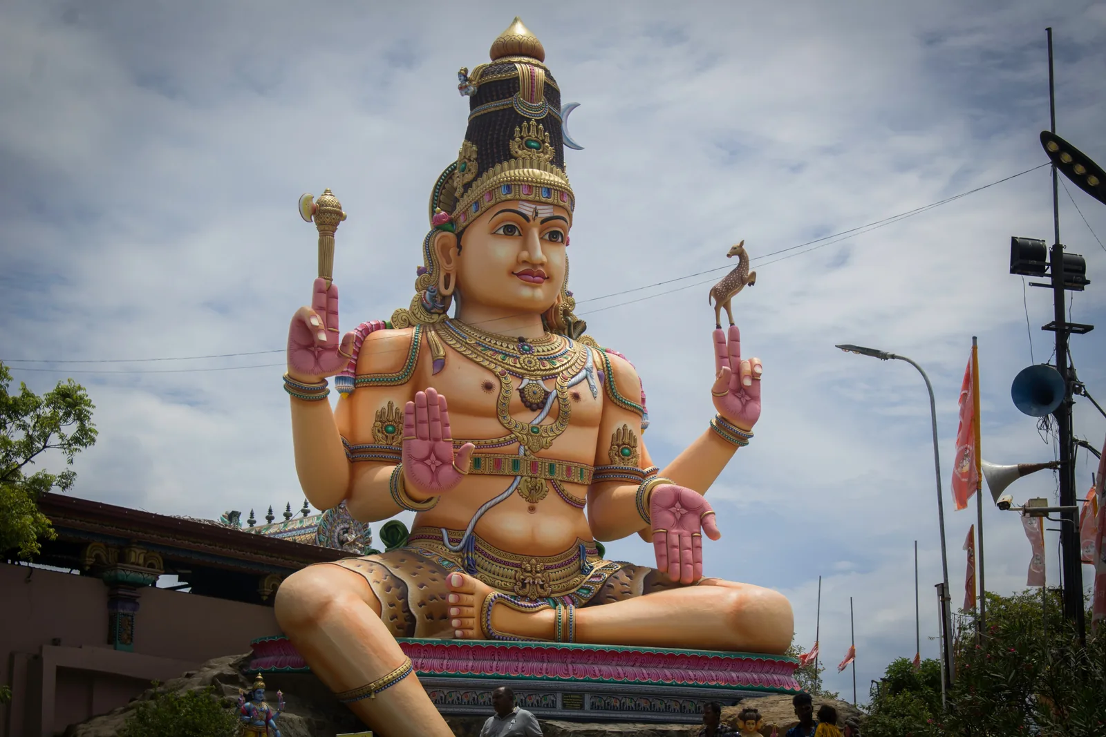 Large colourful statue of the Hindu deity Shiva with multiple arms and golden crown outside a temple in Trincomalee, Sri Lanka